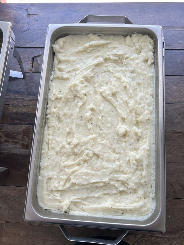 A pan of creamy mashed potatoes flecked with herbs