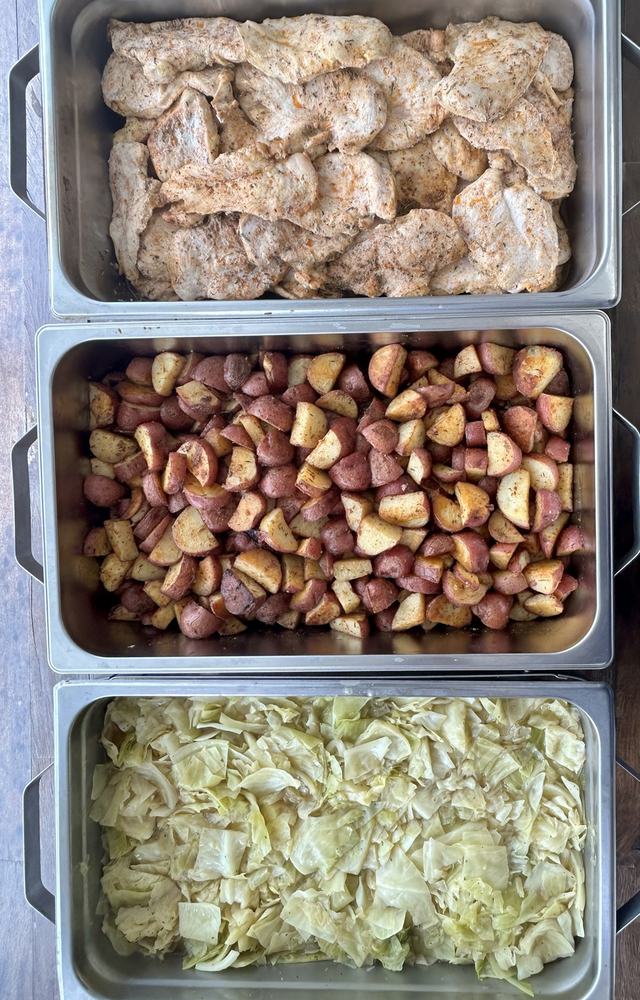 Pans of roasted chicken, herb roasted red potatoes and Southern cabbage