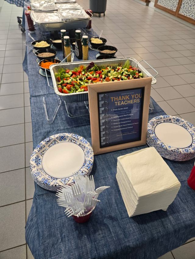 A teacher appreciation lunch buffet with garden salad, toppings and a printed menu